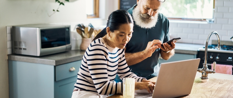 couple using phone and computer