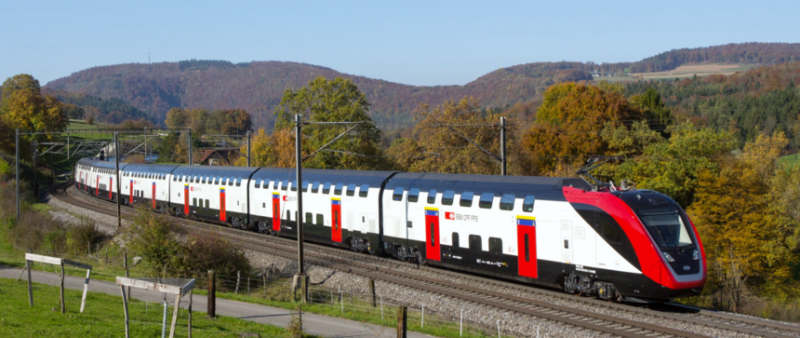 A Swiss Federal Railways (SBB) double- decker train traveling through a scenic landscape, showcasing modern rail technology, digitalization, and predictive maintenance solutions